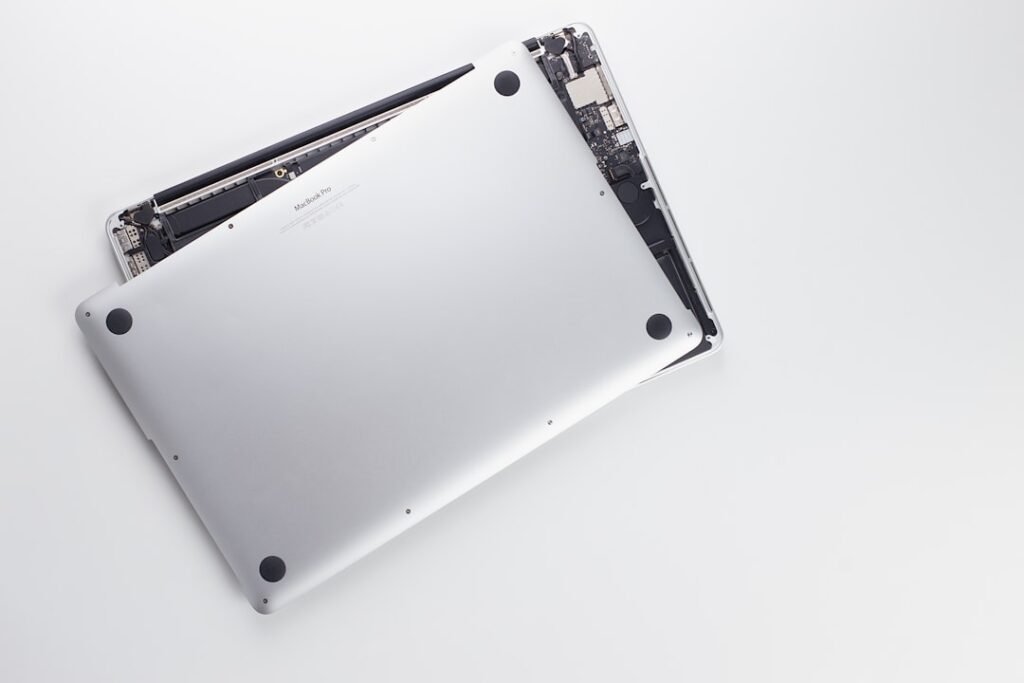 Técnico revisando la pantalla abierta de un MacBook en banco limpio
