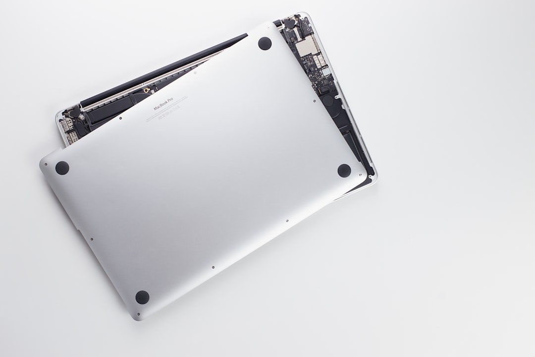 Técnico revisando la pantalla abierta de un MacBook en banco limpio