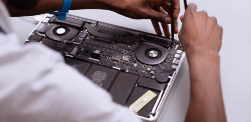 Técnico revisando un portátil Apple sobre mesa de trabajo