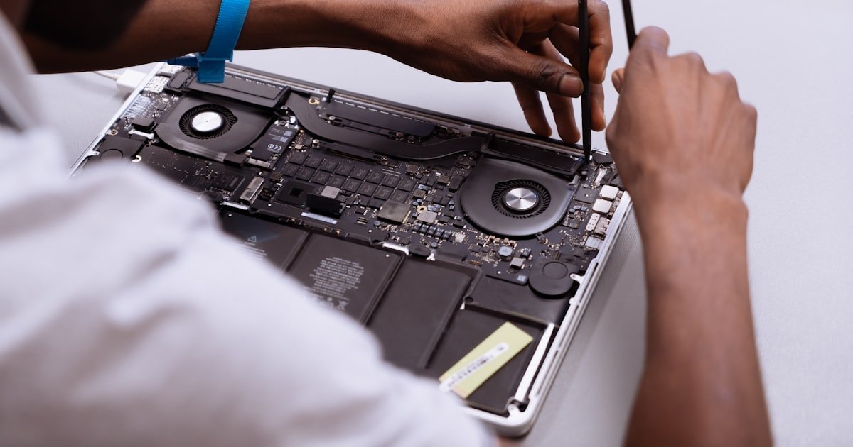 Técnico revisando un portátil Apple sobre mesa de trabajo