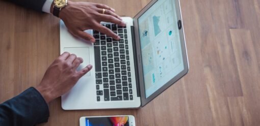 MacBook sobre escritorio con uso del trackpad en primer plano